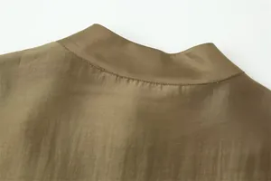 Detailed view of the khaki mandarin collar and smooth fabric texture of a loose shirt