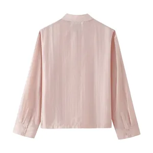 Back view of a pink satin long-sleeved blouse featuring buttoned cuffs and vertical sheen