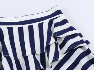 Close-up of ruffled layers and navy blue striped pattern on a summer skirt detail.