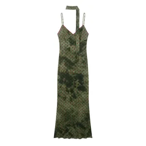 Detail view of a green tie-dye midi dress featuring red polka dots and a matching neck tie.