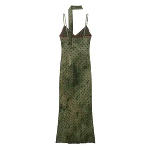 Back view of a green tie-dye midi slip dress with red polka dots and halter neck tie