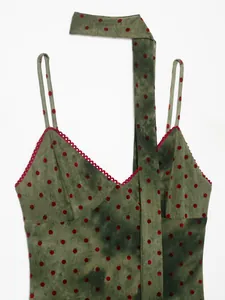 Close-up of olive green tie-dye mesh dress featuring red polka dots and scalloped lace trim