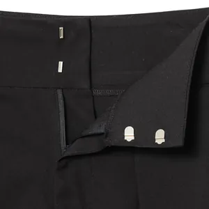 Detailed view of black balloon trousers with durable double hook and zipper closure mechanism.