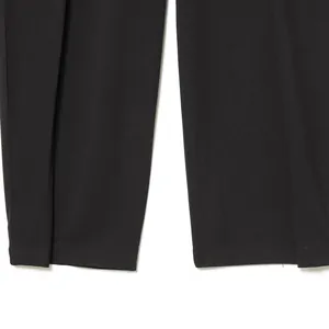 Close-up of stylish black balloon-fit pleated trousers with clean stitched hems.