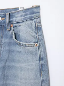Detailansicht einer hellblauen High-Rise-Jeans mit Taschen und Nietenverzierung