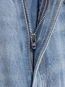 Makro-Detail eines hochwertigen Metallreißverschlusses an blauer Denim-Jeanshose