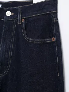 Makro-Detailaufnahme einer dunkelblauen High-Waist-Jeans mit Fokus auf Tasche und Nähte