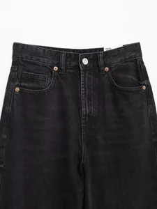Nahaufnahme einer schwarzen High-Waist-Jeans mit geradem Bein und metallenen Nieten