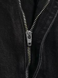 Detaillierte Nahaufnahme des Metallreißverschlusses an einer schwarzen High-Waist-Jeans