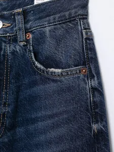 Detailaufnahme einer High-Waist-Jeans mit abgenutzter Tasche und schicken Kupfernieten