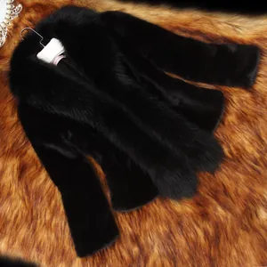 Gros plan montrant la texture riche de la cape en fausse fourrure noire avec col