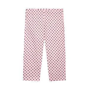 Gedetailleerde platte ligging van een roze Capri-broek met zwarte stippen op wit