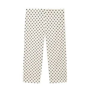 Detail van witte capri-broek met klassiek zwart polkadotpatroon in een platte weergave