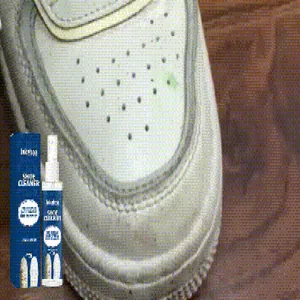 Close-up of JAKEHOE shoe cleaner spray and box next to a stained white leather sneaker detail