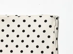 Macro-detailweergave van de onzichtbare rits op witte stof met zwarte stippenprint