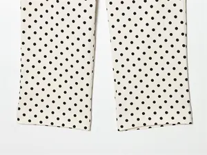 Gedetailleerd macrozicht op het zwarte polkadatpatroon op de zoom van de Capri-broek