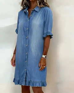 Detail view of a light blue denim shirt dress featuring ruffle sleeves and hemline.