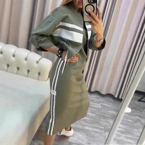 Close-up view of a stylish green casual two-piece jacket and striped midi dress set