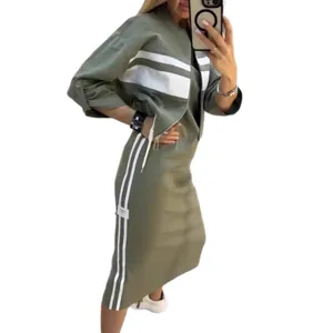 Side profile detail of the olive green zip-up jacket and matching skirt with stripes