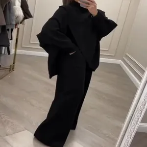 Κομψό μαύρο πλεκτό σετ δύο τεμαχίων με oversized πουλόβερ και ασορτί παντελόνι με φαρδύ πόδι.