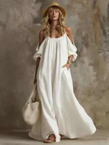 Elegant detail of a flowy white cold shoulder maxi dress with convenient pockets.