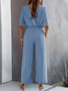 Back view of an elegant light blue short sleeve wide leg jumpsuit with textured fabric