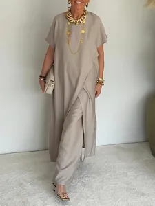Elegante set due pezzi con top asimmetrico drappeggiato e pantaloni larghi coordinati.