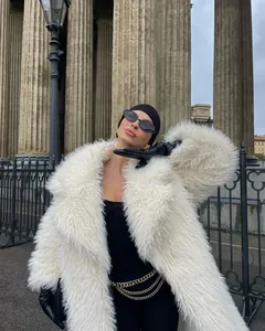 Detailed shot of white long faux fur winter coat with shaggy texture and lapel design