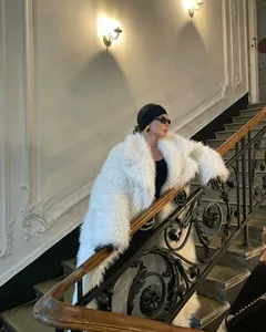 Elegant long white faux fur coat with shaggy snow fox effect for chic winter fashion.