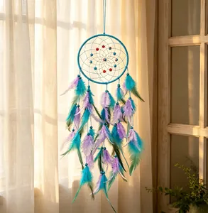Kleurrijke dromenvanger met turquoise en paarse veren hangend bij een zonnig raam