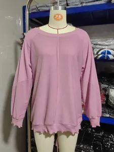 Detail des pinkfarbenen Sweatshirts mit Kontrastnähten und Rippbündchen an der Puppe