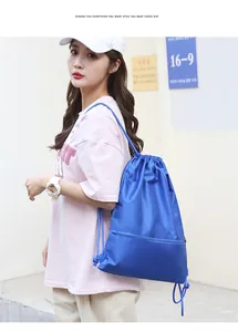 Blue Oxford fabric drawstring backpack being worn by a model in a casual outdoor setting
