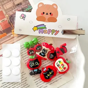 Detailed macro shot of cute apple-themed cat resin hair clips and DIY accessories.