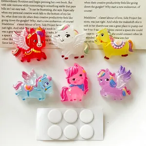 Detalle de seis dijes de poni de resina de colores y puntos adhesivos para manualidades