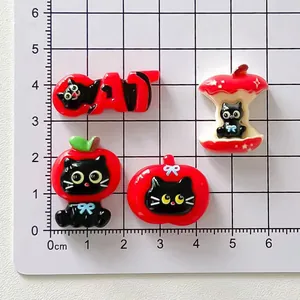 Close-up of DIY black cat resin charms on a centimeter scale mat