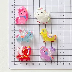 Surtido de dijes de poni de resina de colores para joyas DIY sobre una cuadrícula