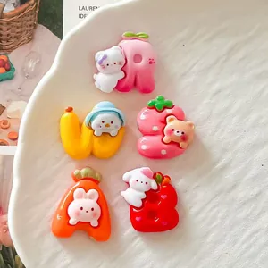 Detailed view of cute cartoon animal fruit letter resin charms for DIY crafts.