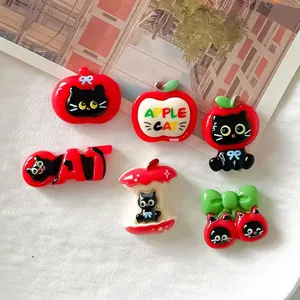 Detailed macro view of DIY resin apple cat charms for phone case decoration and crafts.