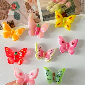 Primer plano de dijes de mariposa de resina con motivos frutales para manualidades e imanes