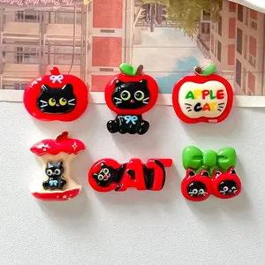 Close-up detail of cute resin black cat and red apple DIY flatback craft accessories