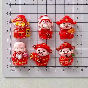 Miniature cartoon Chinese God of Wealth resin figurines displayed on a cm scale mat