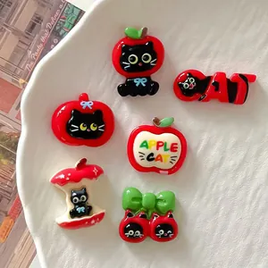Detailed macro view of various cute DIY resin cat and apple themed accessories for crafts