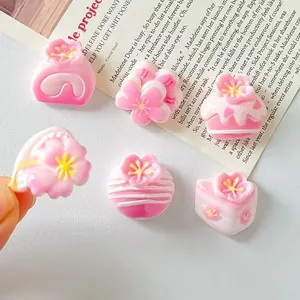 Close-up of mini resin cherry blossom and cupcake DIY charms for hair clips and crafts