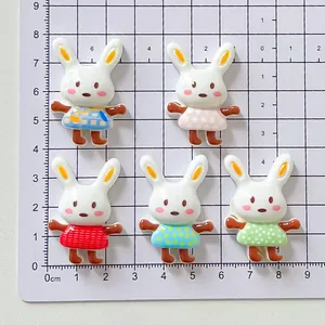 Sortiment von 5 niedlichen Harz-Hasen-Anhängern mit bunten Outfits auf einer Schneidematte