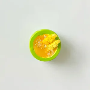 Detailed macro view of a miniature mango dessert resin charm featuring pineapple toppings