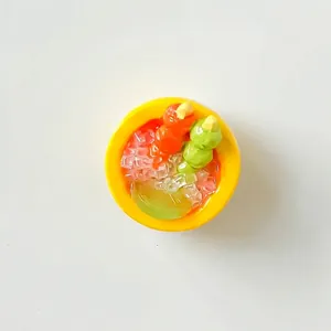 Detailed top view of miniature resin dessert bowl with colorful fruit skewers and sago.