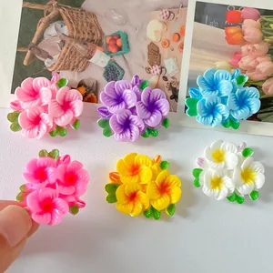 Close-up of shiny resin flower charms in various colors for DIY jewelry making