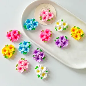 Close-up of colorful glossy resin flower patches arranged on a white decorative tray