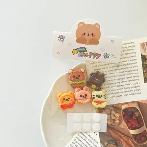 Detailaufnahme von Miniatur-Anhängern in Tierform mit Klebepunkten für DIY-Bastelprojekte.