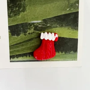Primo piano di un ciondolo natalizio festivo a forma di calza in resina rossa e bianca